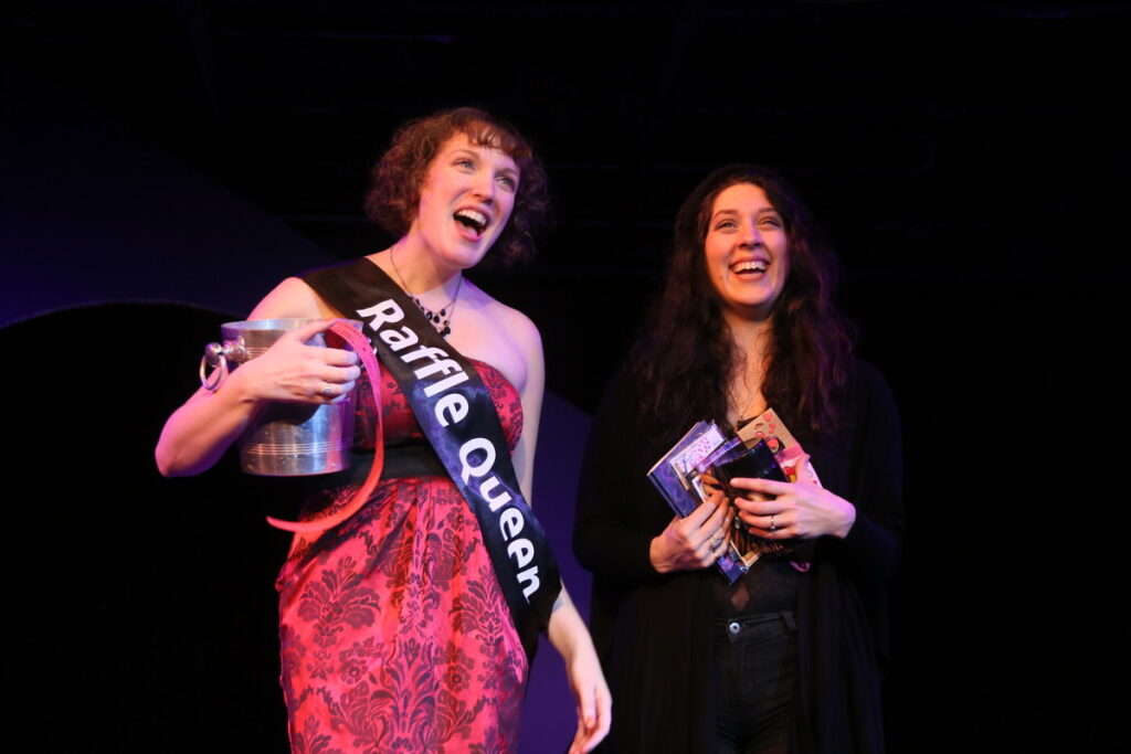 Two performers on stage with a black background.
